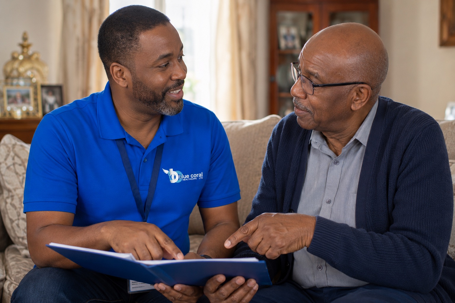 Blue Coral Healthcare carer discussing a care plan with an elderly man at home in Rotherham